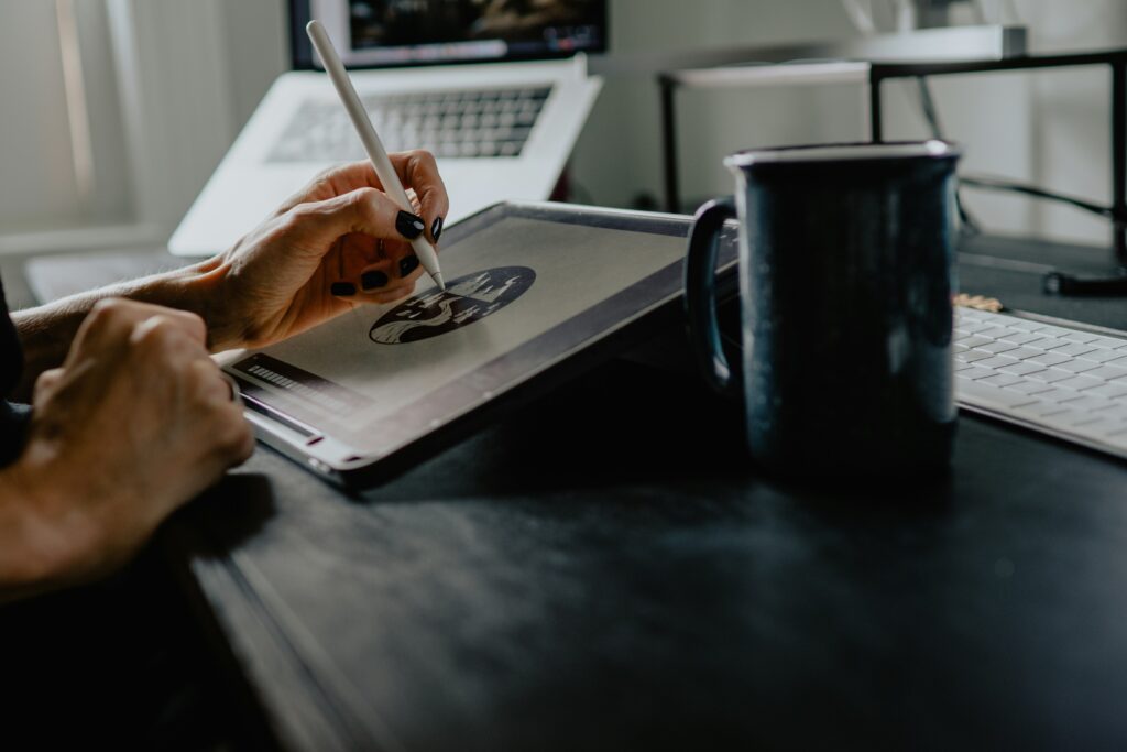 Photograph of a cartoonist drawing on a tablet