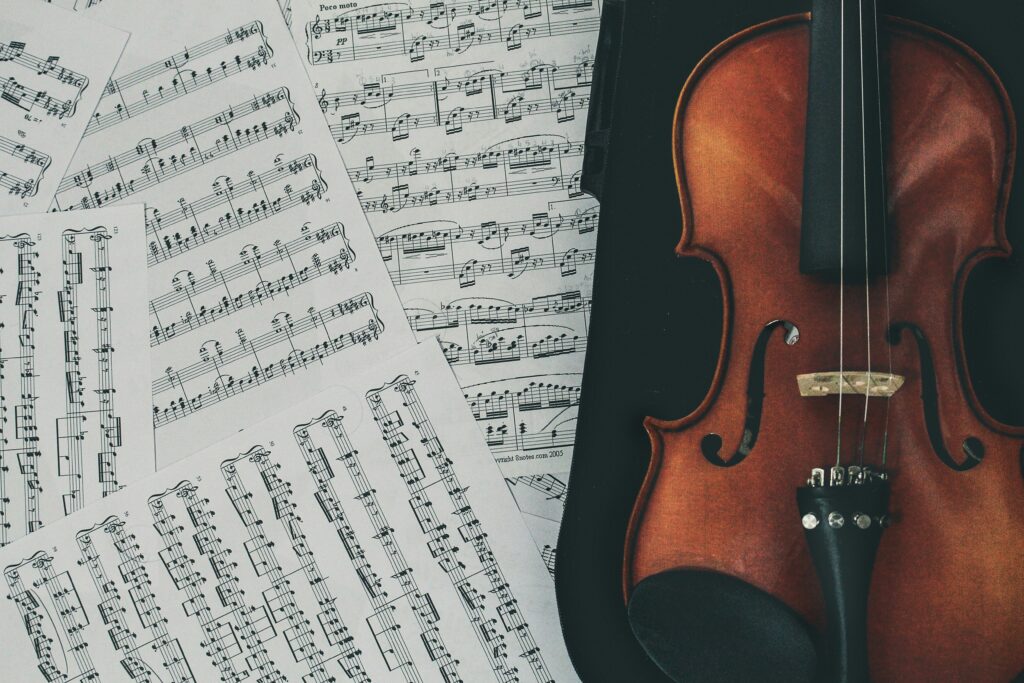 A birds-eye photograph of a violin atop sheet music.