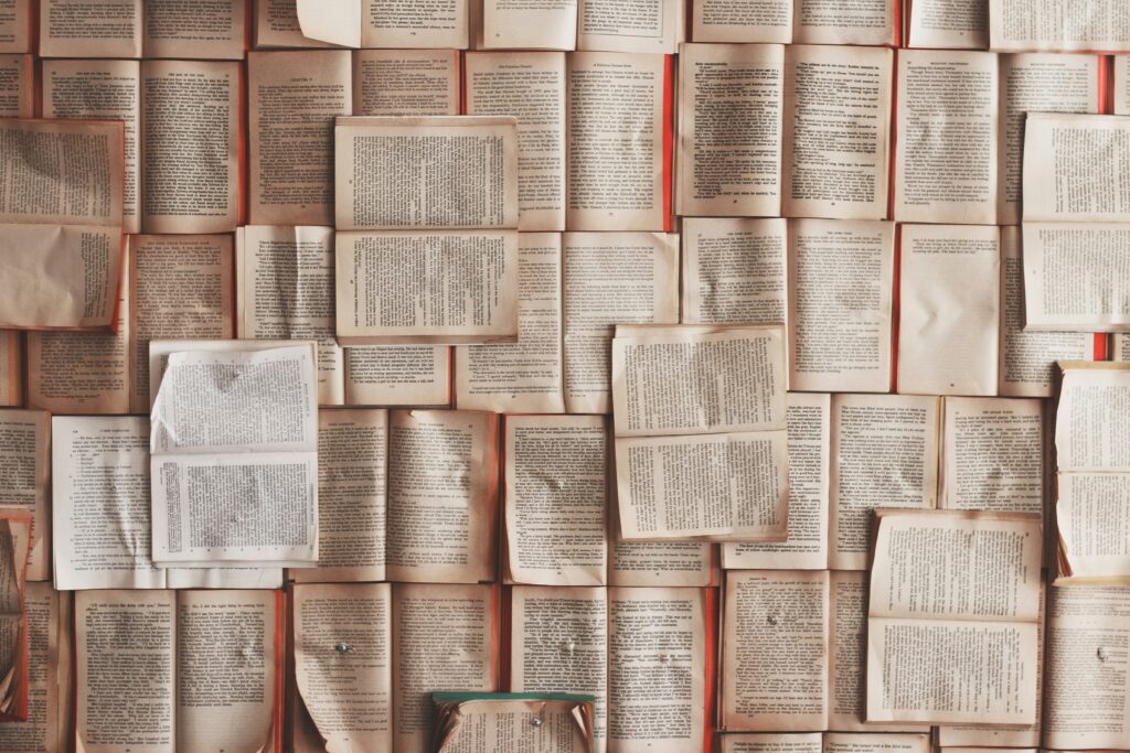 A birds eye photograph of vintage books laid out covering a table.