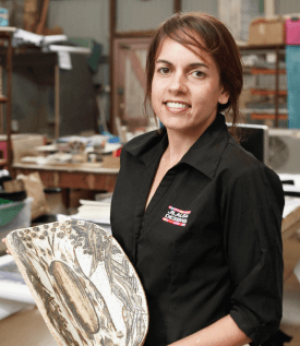 Photo of visual artist Jilalga Murray-Ranui holding artwork inspired by works of art inspired by the Pilbara landscape, people, animals and lifestyle.