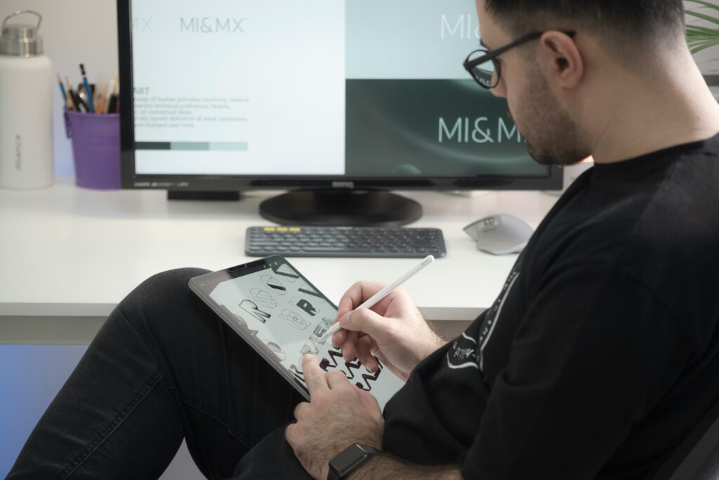 A photograph of a graphic designer preparing work on his tablet